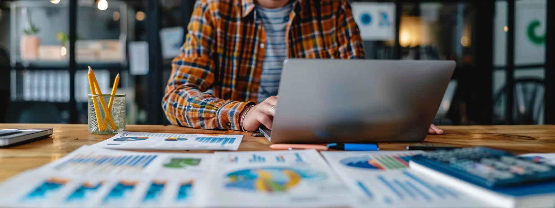 a person sitting at a desk with a laptop, analyzing data and graphs related to online visibility and content creation strategies for a melbourne enterprise.