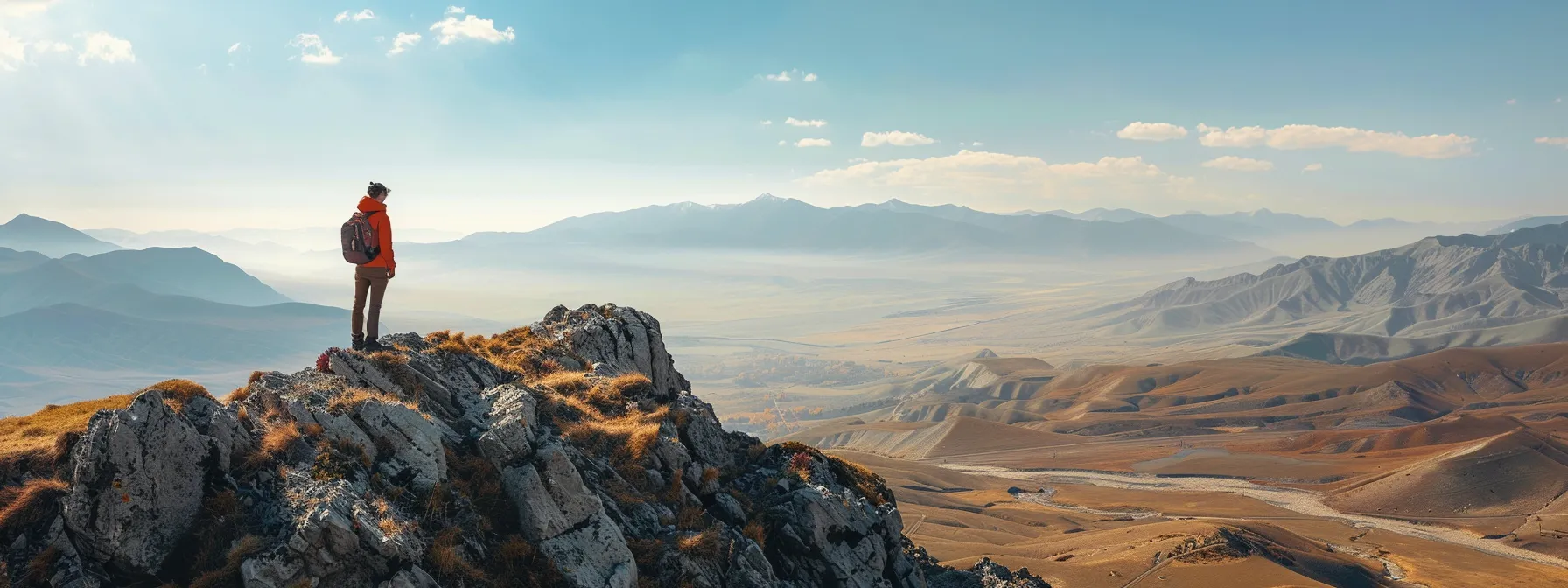 a person standing on a mountaintop, looking out at a vast landscape, with a look of determination on their face.