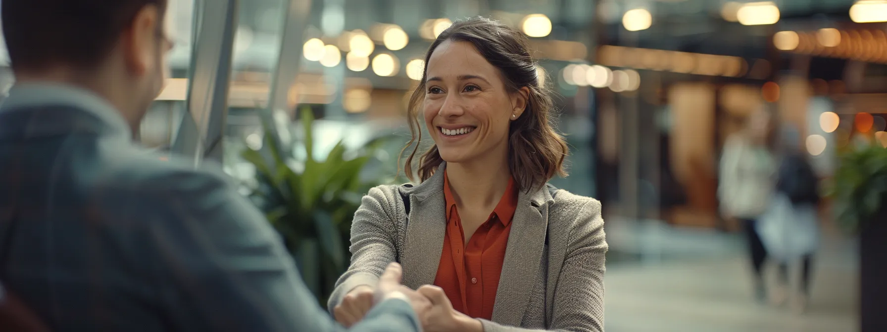 a salesperson smiling as they calmly shake hands with a client who is politely declining their offer.