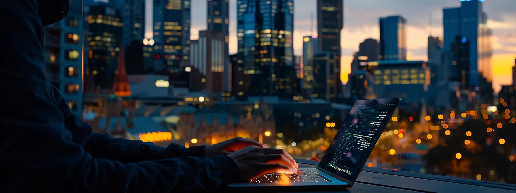 an individual typing on a laptop with melbourne skyline in the background.